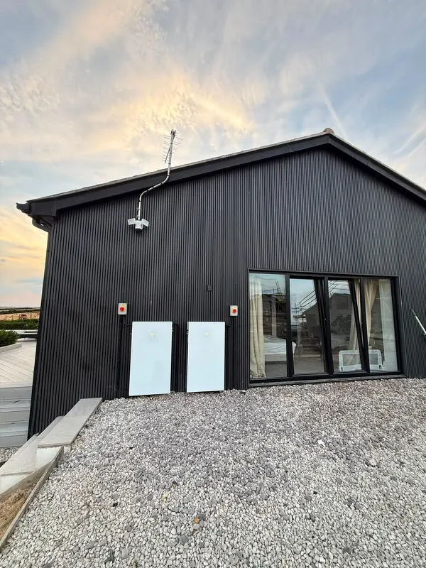Battery units on a black timber-clad building